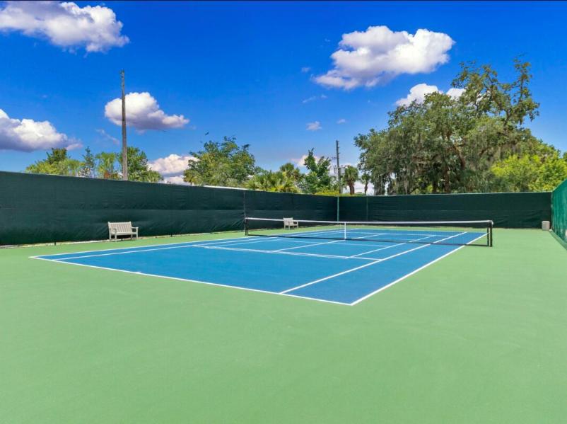 a tennis court with two benches on it at Camaro in Orlando