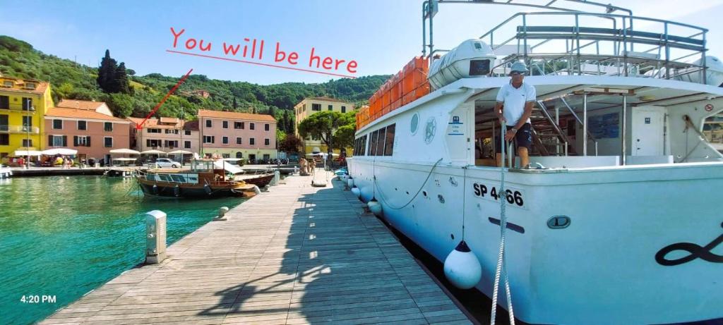 a man standing on a boat at a dock at Cinque terre - Le Grazie On the Waterfront in Portovenere