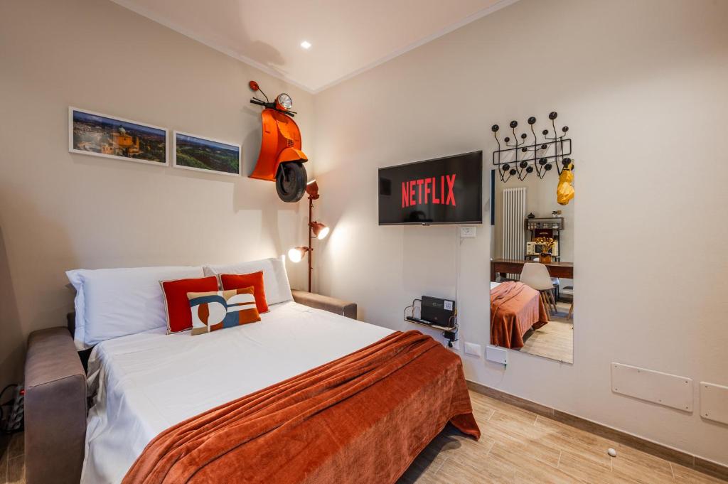 a bedroom with a bed and a tv on the wall at Sui Tetti di Bologna centro, Casa Dei Colori in Bologna
