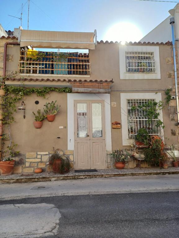 a house with a door and potted plants on it at La Casa Di Piero e Mary in Brucoli