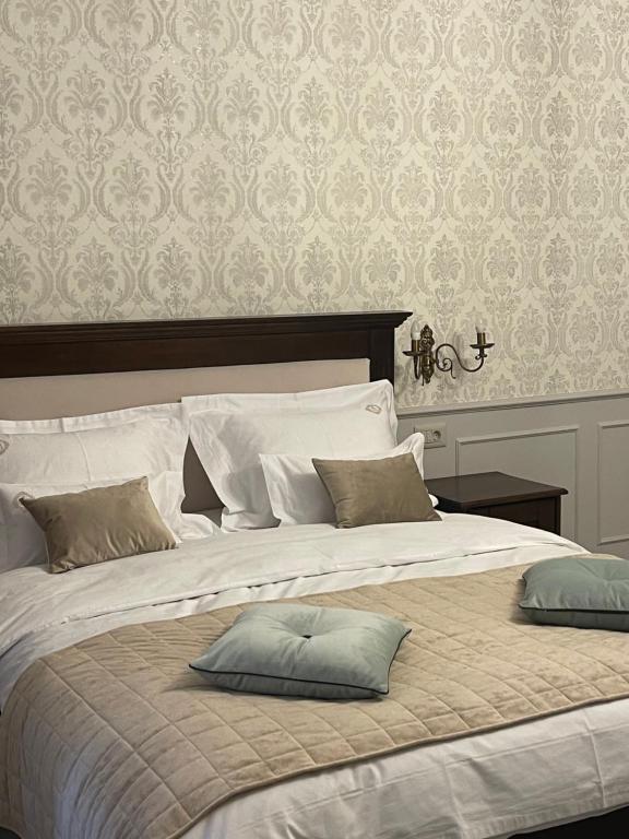 a large bed with two pillows on top of it at Casa Salzburg in Sibiu