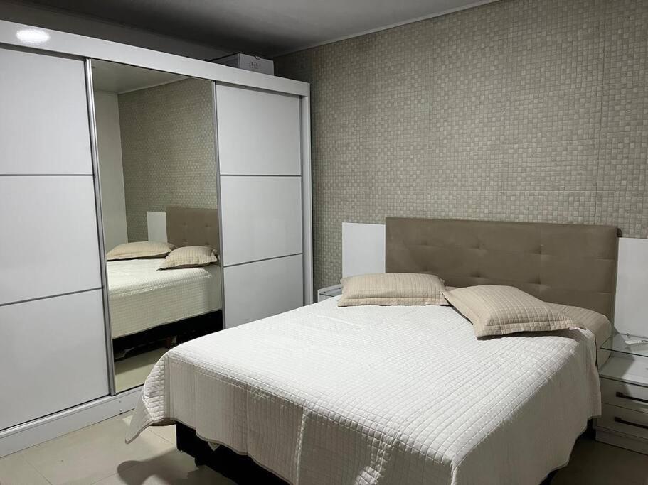 una camera da letto con un letto e un grande specchio di Casa em Anchieta completa próximo a castelhanos e Iriri a Anchieta