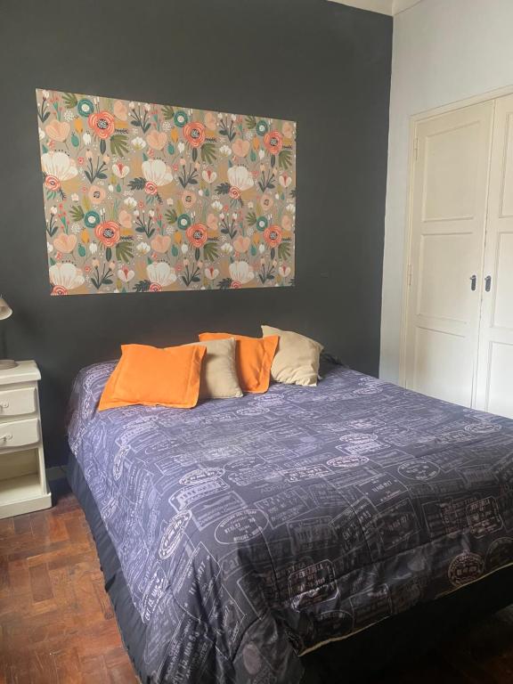 a bedroom with a bed with a painting on the wall at Excelente ubicación in Mar del Plata