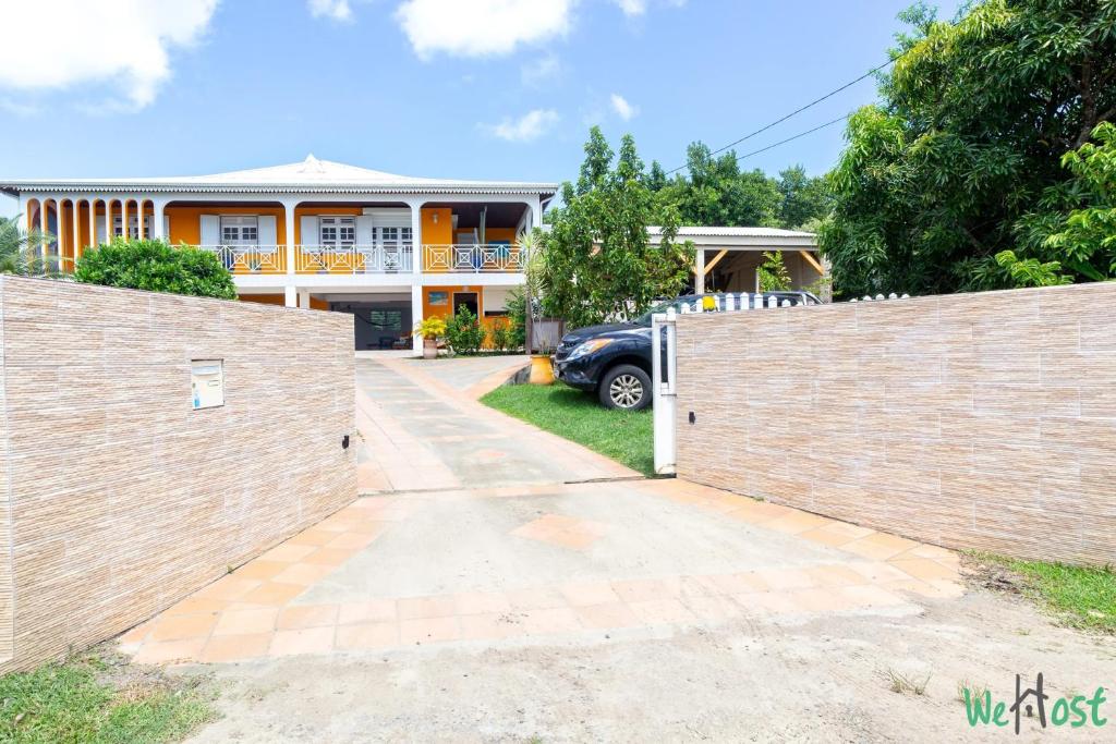 a house with a gate in front of a driveway at Appartement charmant à Le Marin - 48 m², jardin in Le Marin