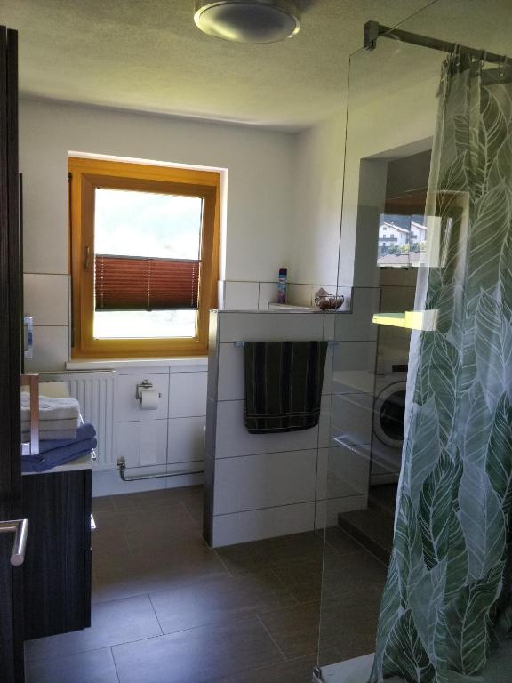 bagno con doccia e finestra di Kurort Tirol a Bad Häring