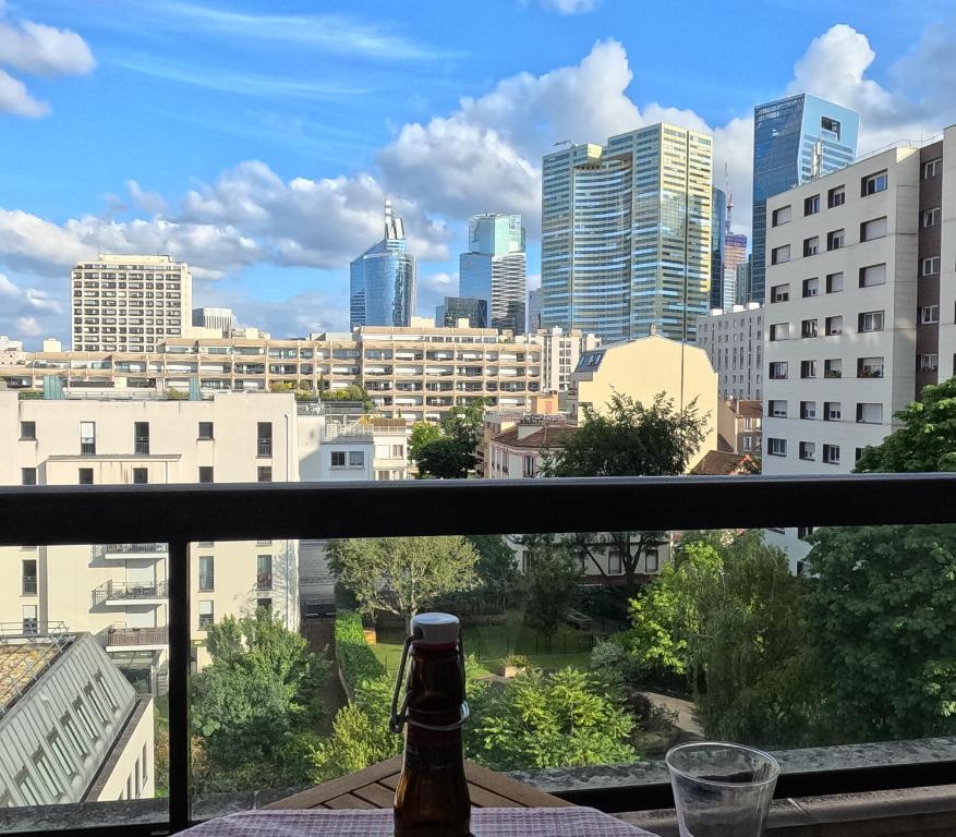 d'un balcon offrant une vue sur les toits de la ville. dans l'établissement Superbe appartement Paris Courbevoie La Défense, à Courbevoie