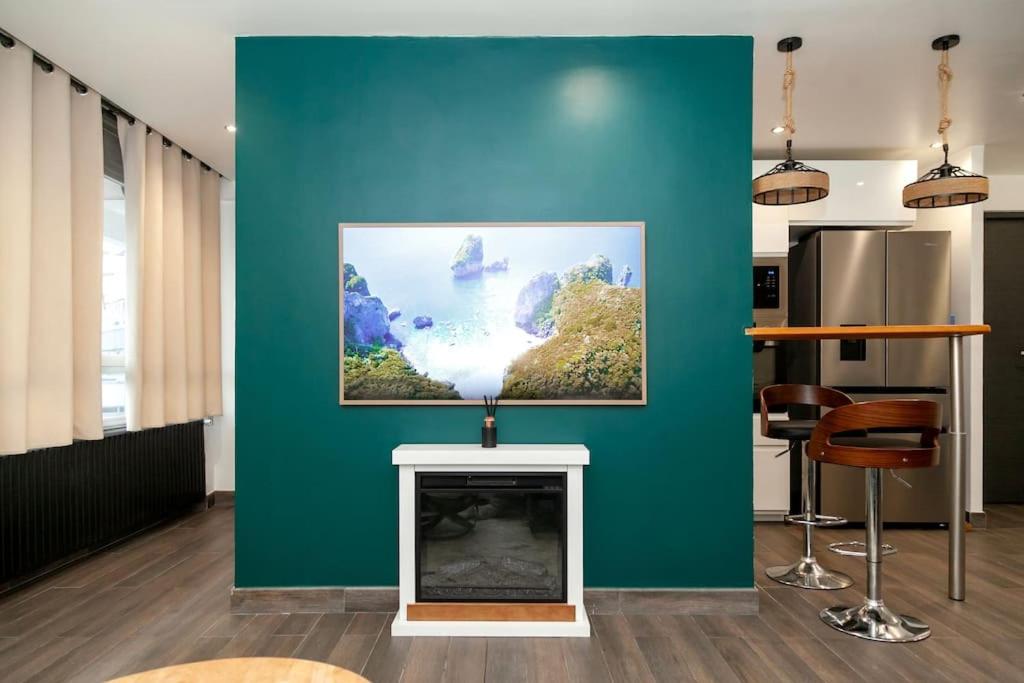 - un salon avec un mur vert et une cheminée dans l'établissement Appartement Paris - La Défense, à Nanterre