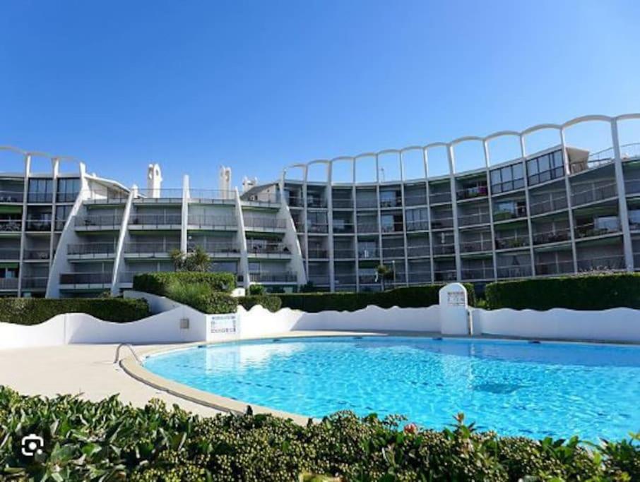 un grand immeuble d'appartements avec une grande piscine dans l'établissement 1er ligne piscine au couchant, à La Grande Motte