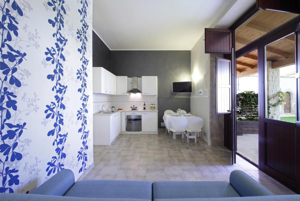 a living room with a blue couch and a kitchen at Casal Sikelio in Cassibile