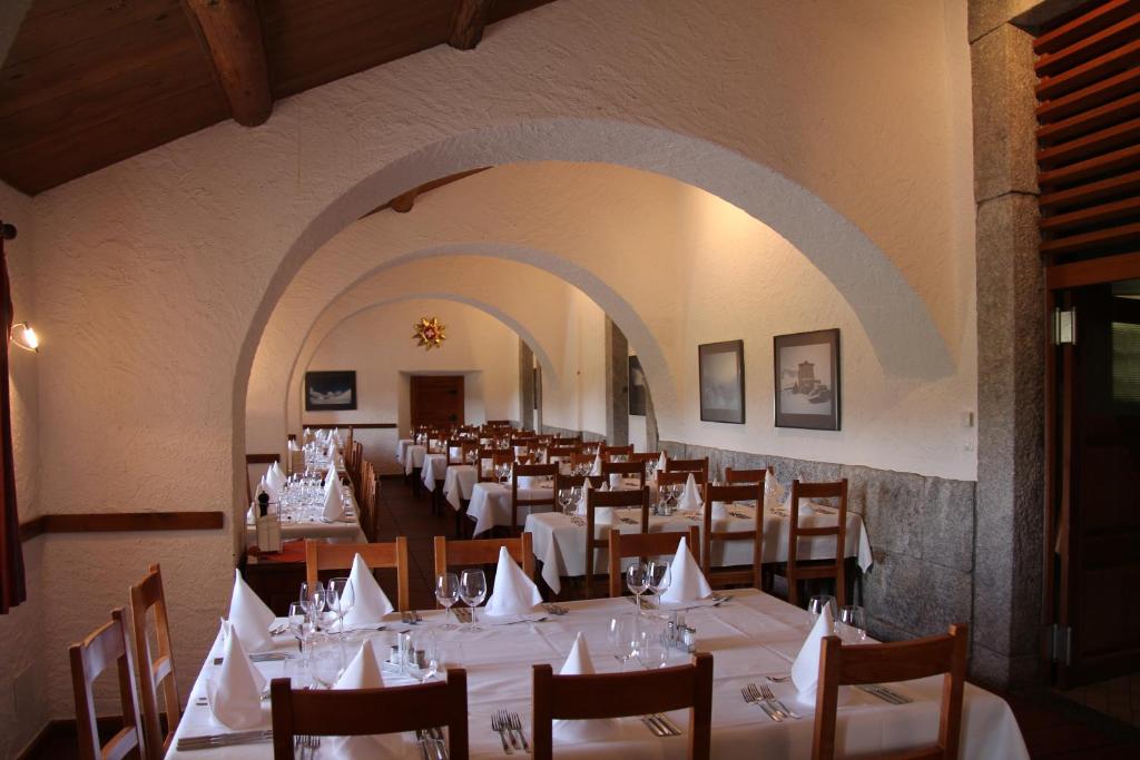 een eetkamer met witte tafels en stoelen bij Albergo San Gottardo in Airolo