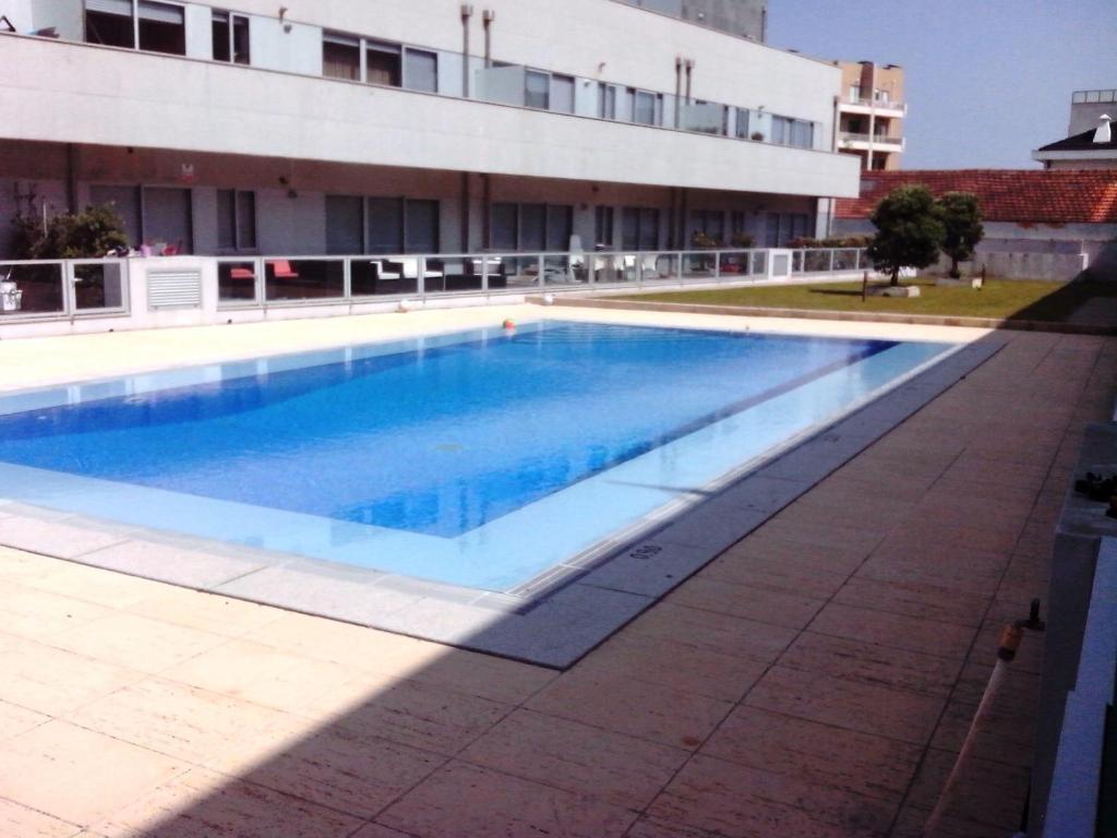 a large swimming pool in front of a building at Oporto city and Beach apartment in Lavra