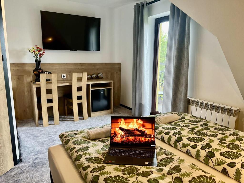 laptopa siedzącego na łóżku w pokoju w obiekcie Pod Sosnami Termy 450m -20 procent na Termy w Białym Dunajcu