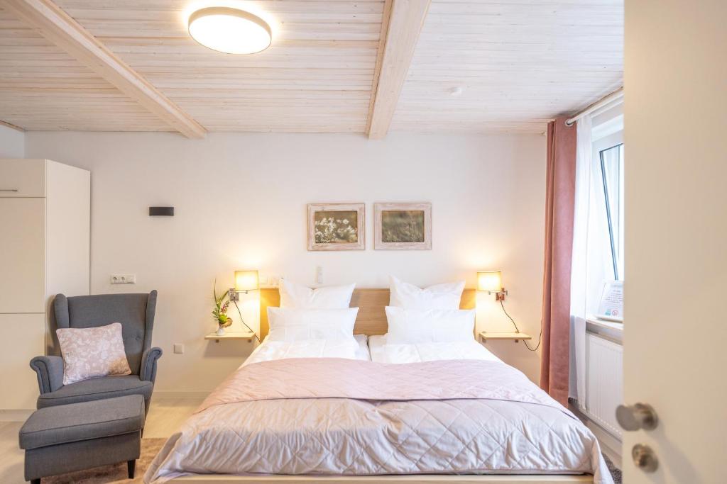 a bedroom with a large bed and a chair at Apartment Wasenberg in Willingshausen