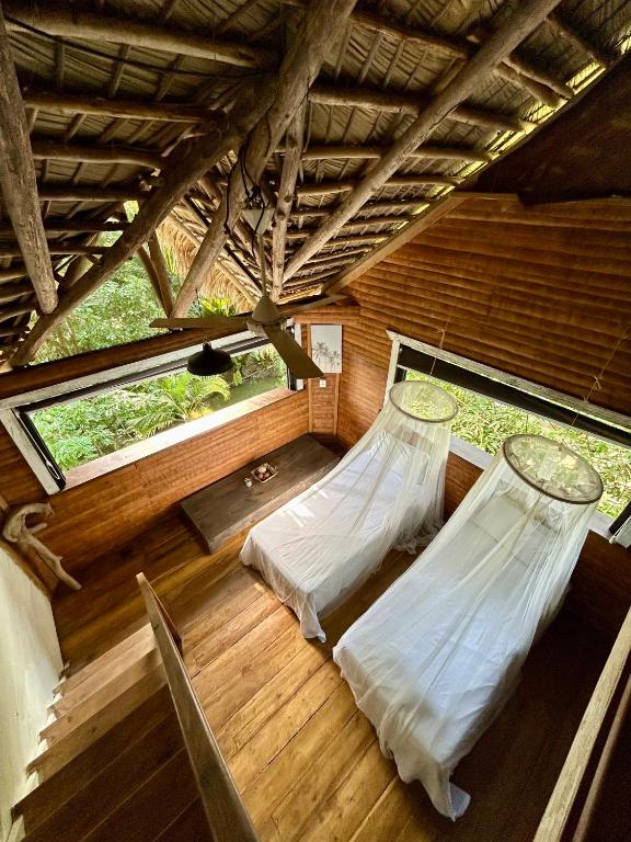 two beds in a room with wooden floors and windows at ZÂRIA Hotel & Retreat Center in El Valle