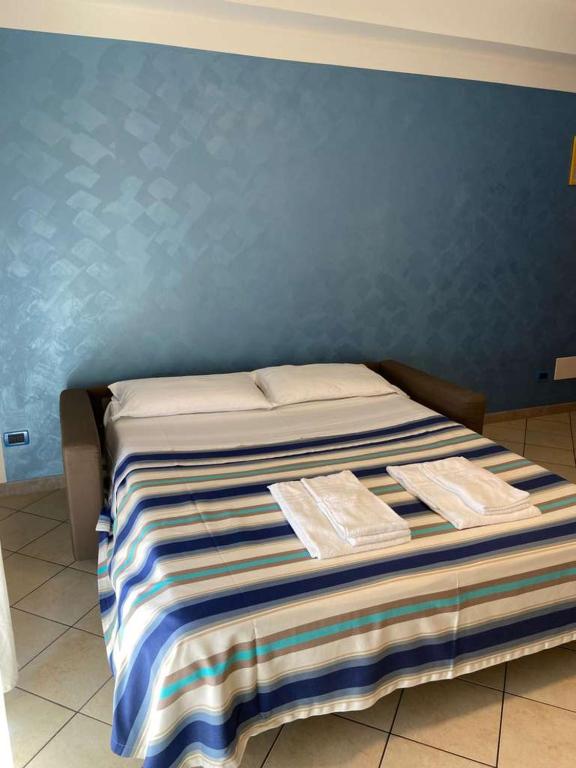 a bed in a room with a blue wall at Residence Cigno in Rimini