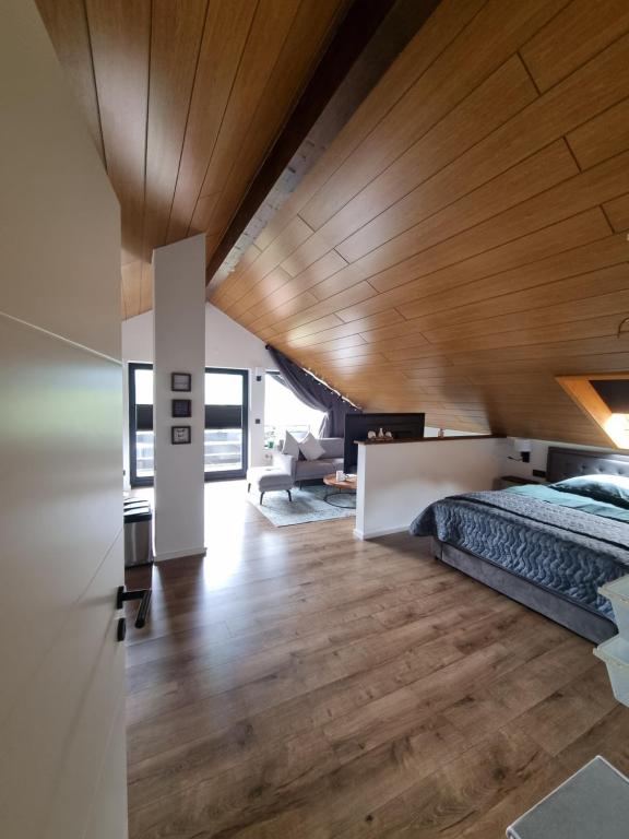 une chambre avec un lit et un plafond en bois dans l'établissement Miu's Roof, à Alpirsbach