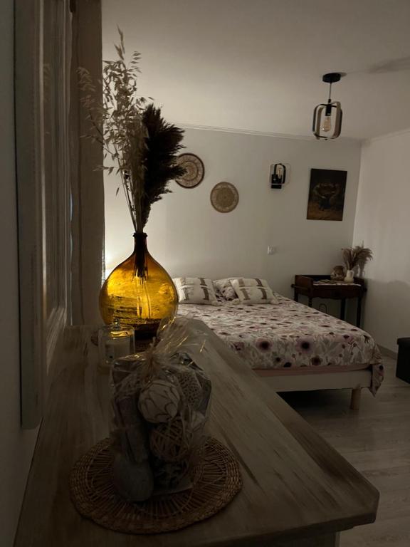 a room with a vase on a table with a bed at Mes Chambres à la campagne in Orange
