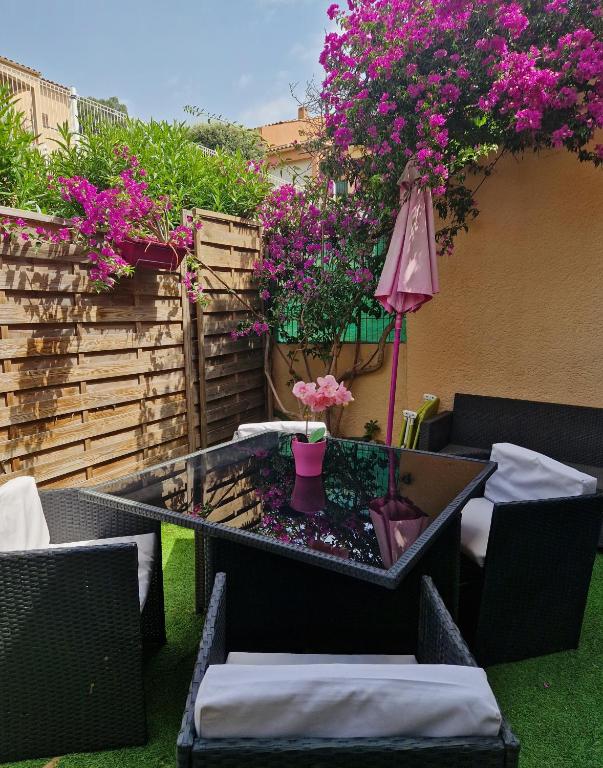 - une terrasse avec une table, des chaises et des fleurs dans l'établissement T2 rez de jardins, à Cavalaire-sur-Mer