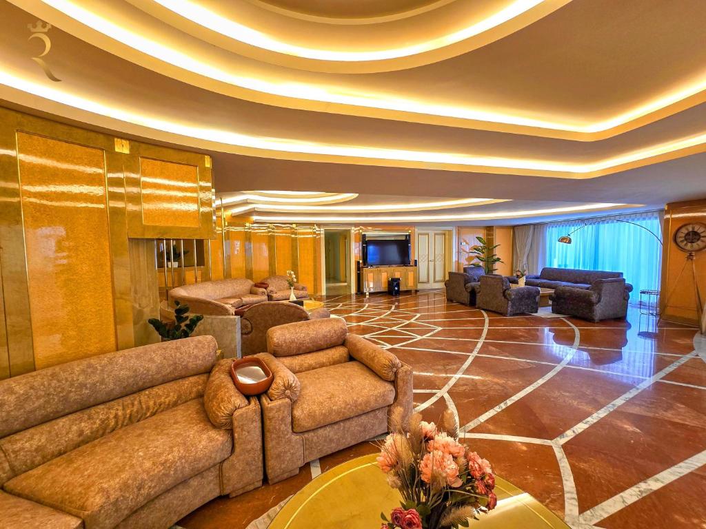 un ampio soggiorno con divani e televisione di Presidential Penthouse - Vintage Italian Elegance Near Corniche a Abu Dhabi