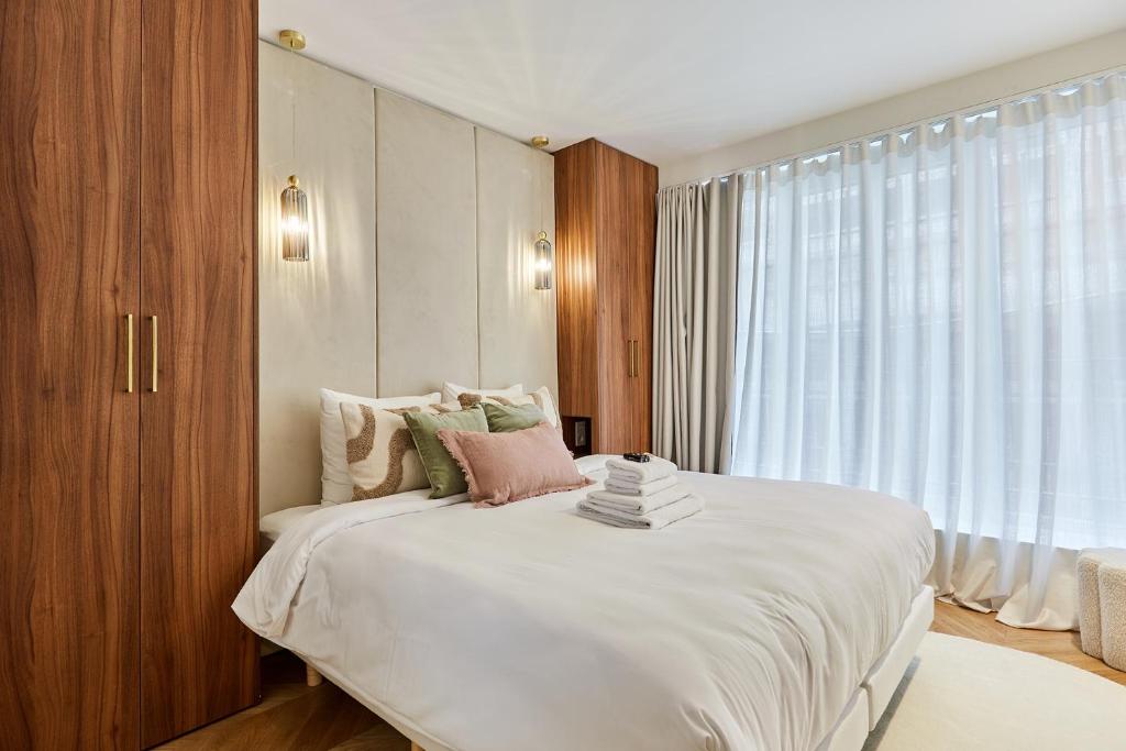 une chambre avec un grand lit blanc et une fenêtre dans l'établissement Residence 2 Apartments Center of Paris by Studio Prestige, à Paris