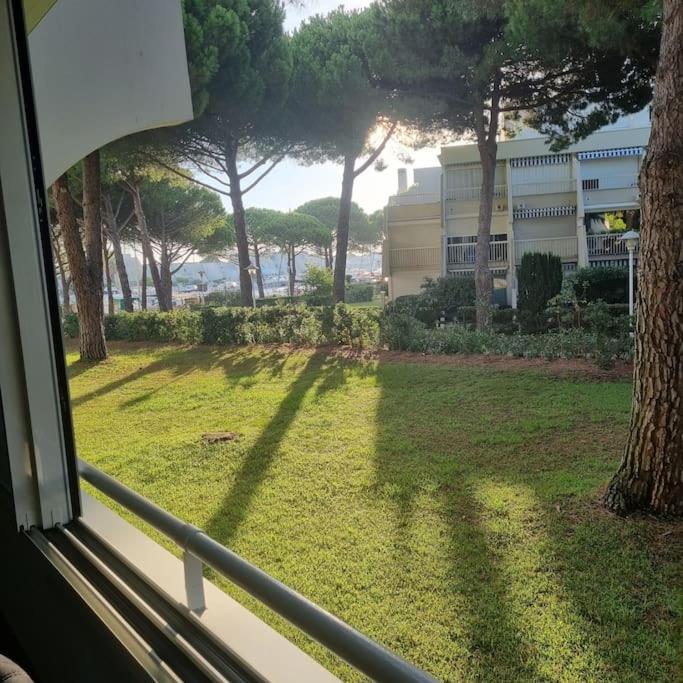 Elle offre une vue sur une cour avec des arbres et un bâtiment. dans l'établissement Joli T3 à 200M Plage Sud 4 personnes Parking Calme, au Grau-du-Roi