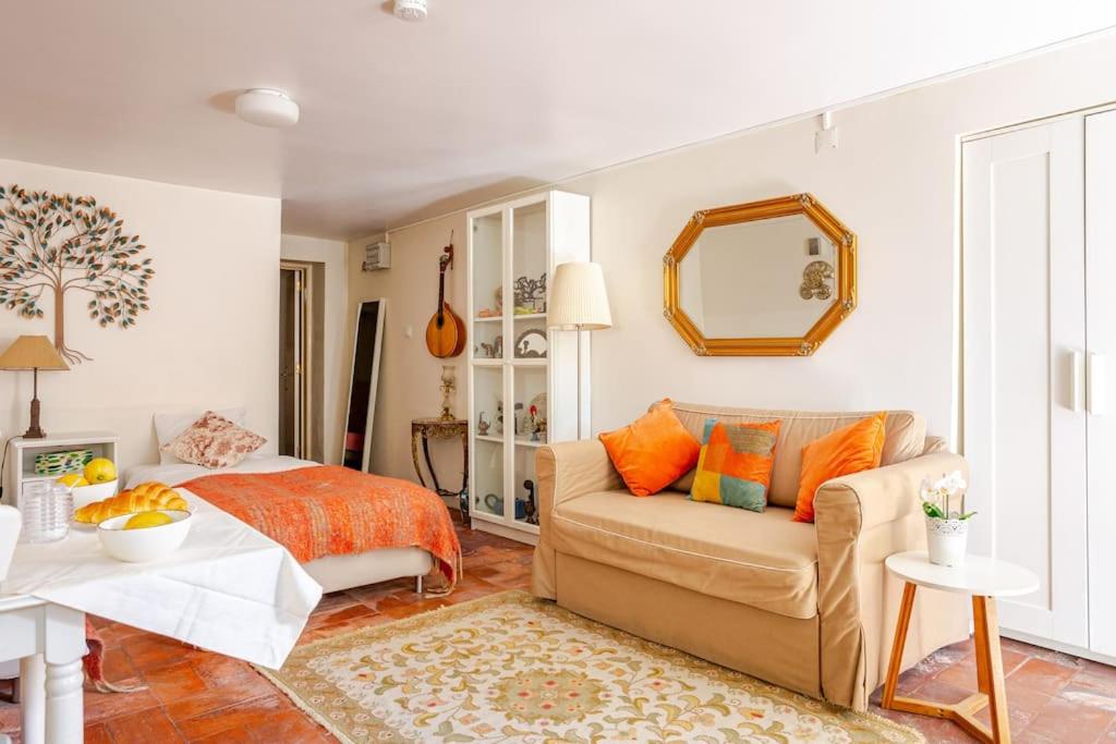 een woonkamer met een bank en een bed bij Studio & Garden in Lissabon
