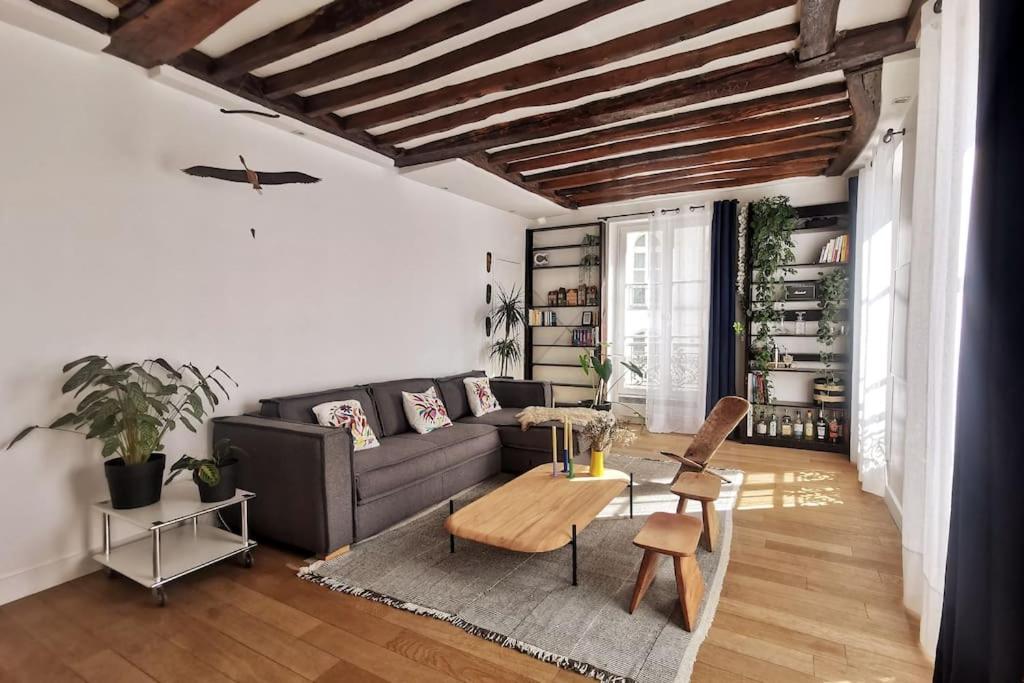 un salon avec un canapé et une table dans l'établissement Appartement Place des Vosges, 1 chambres 4 P, à Paris