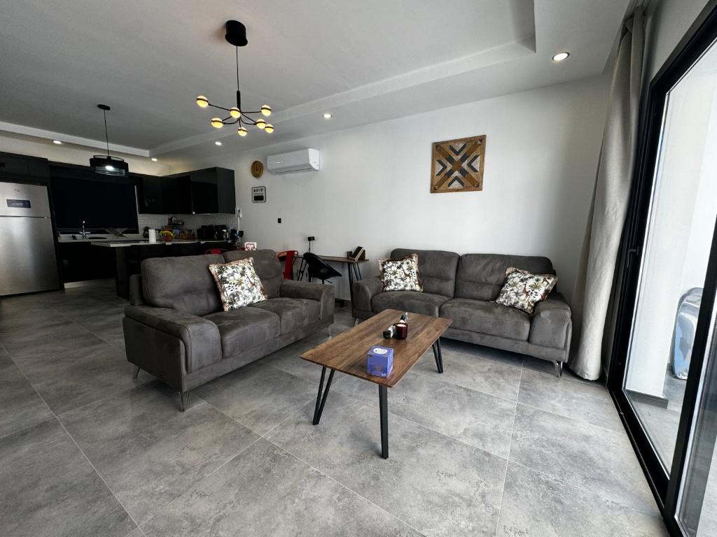a living room with two couches and a table at Blue Island 1 & 2 Holiday Rentals in Karavas