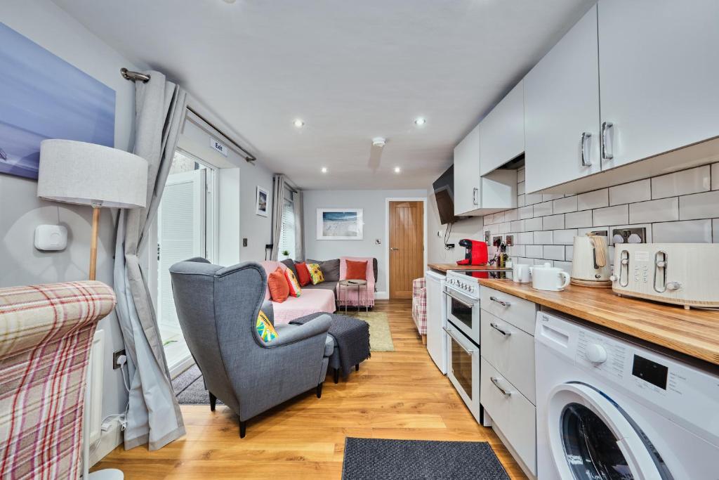 eine Küche mit einem Sofa und einem Stuhl in einem Zimmer in der Unterkunft Princess Green 4 - Portrush by the Sea in Portrush