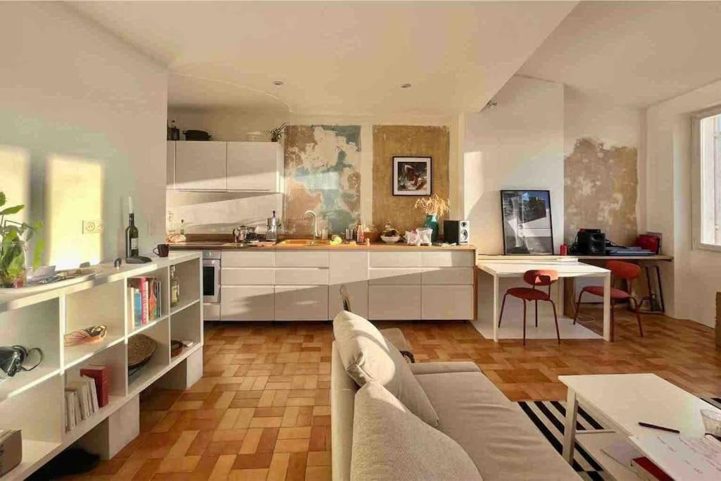 un salon avec un canapé et une cuisine dans l'établissement appartement architecte, à Marseille