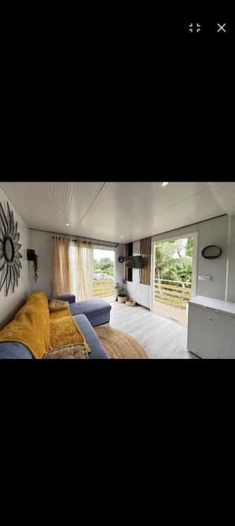 a bedroom with a bed and a large window at La Maison du haut! in Sainte-Rose