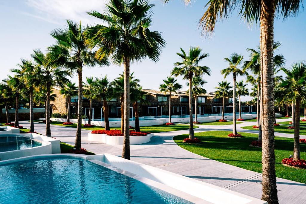 a resort with palm trees and a swimming pool at Kallithea Village hotel in Kallithea Halkidikis