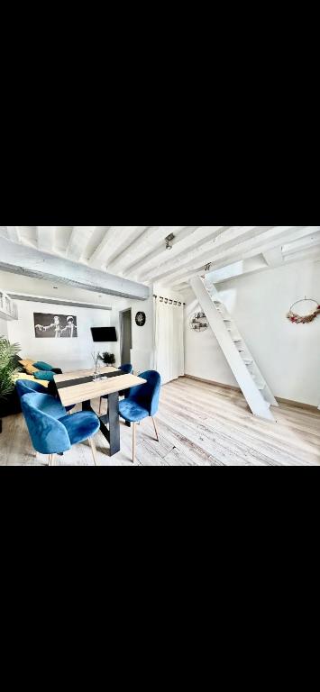 une salle à manger avec une table et des chaises bleues dans l'établissement Glycine, à Orléans
