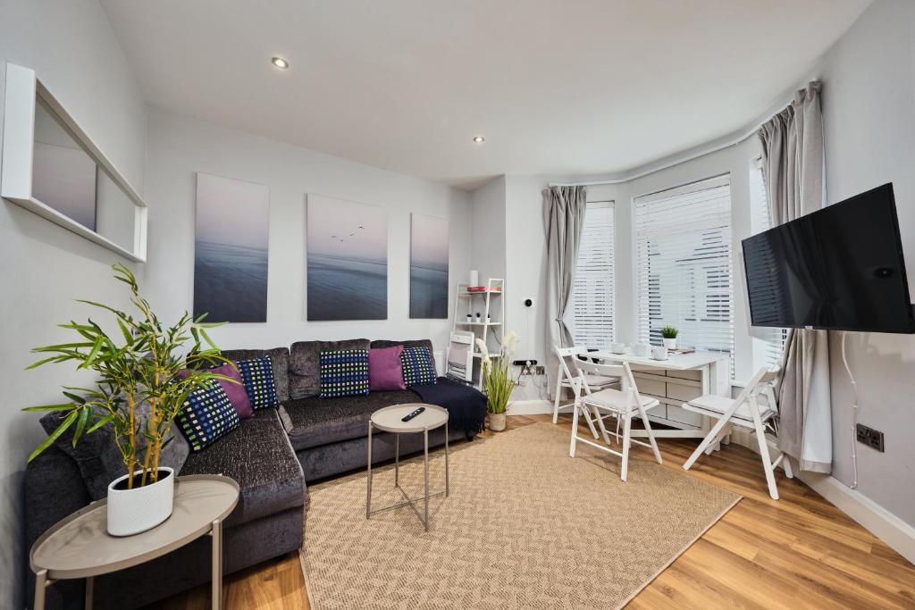 a living room with a couch and a table at Princess Green 2 - Portrush by the Sea in Portrush