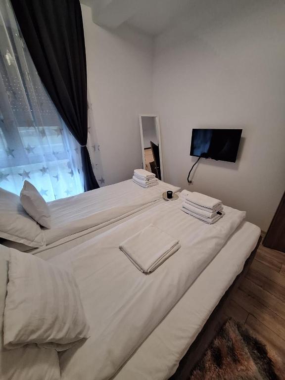a large white bed in a room with a window at AquaTherm Felix in Sînmartin