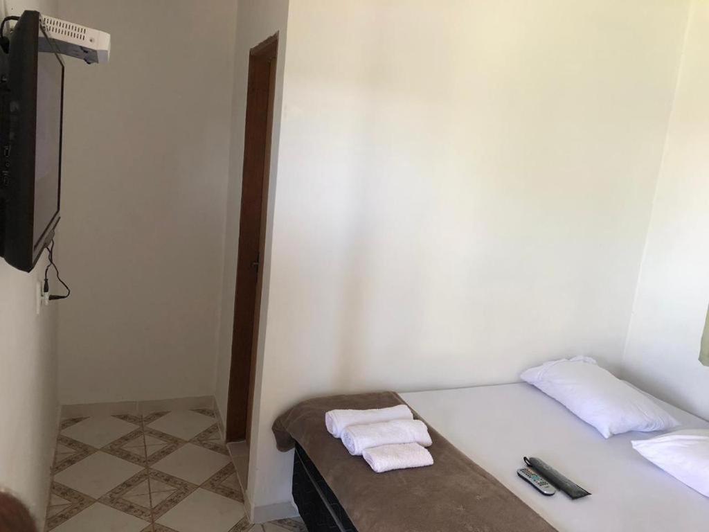 una camera bianca con un letto e asciugamani di Clube de pesca e pousada boa sorte a Itauçu
