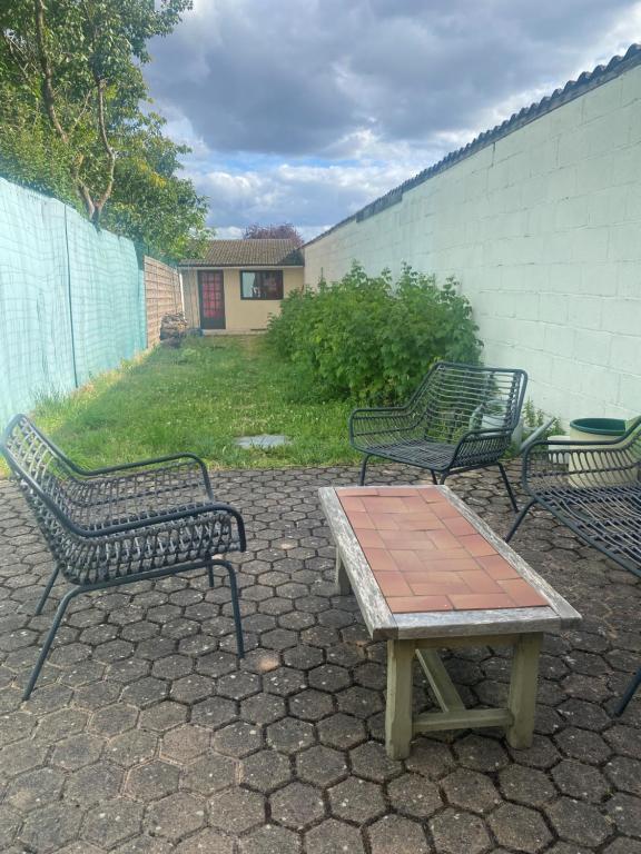 trzy ławki w parku i stół na patio w obiekcie Joli Maison calme 10 Mn de Paris st LAZARE w mieście Argenteuil