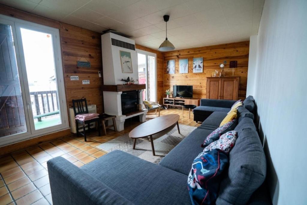 un salon avec un canapé bleu et une table dans l'établissement Chalet les 3 Porches - maeva Home - Chalet 6 pièces 15 personnes - Exclusive MAE-3221, à Vars