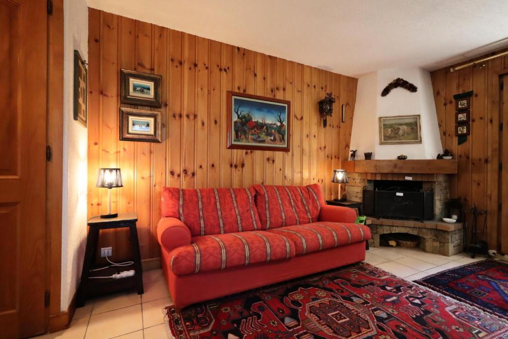 - un salon avec un canapé rouge et une cheminée dans l'établissement Résidence Les Eaux Rousses - Les Eaux Rousses MAE-9964, aux Houches