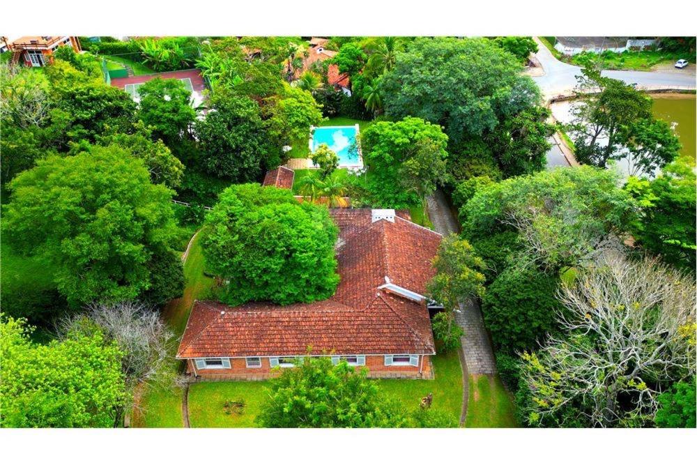 ペトロポリスにあるVilla do Lago Nogueiraの木立の中に赤い屋根の家