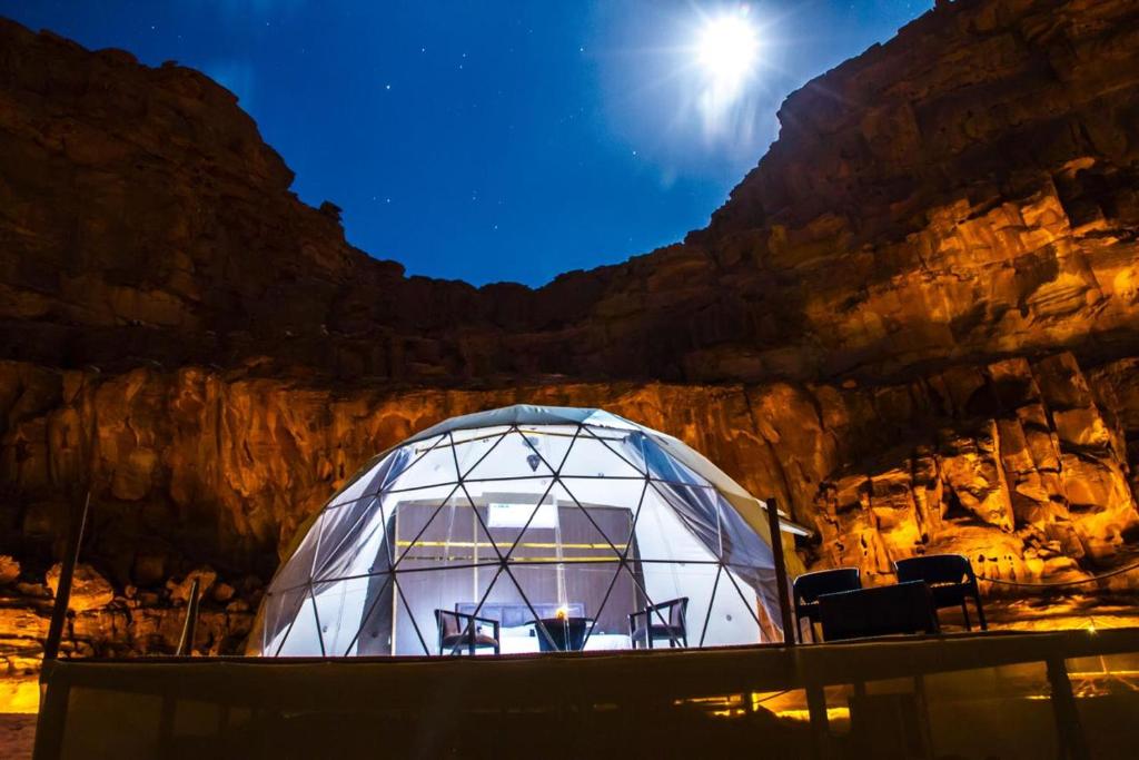 ワディ・ラムにあるWadi Rum Star Viewの崖の前にある椅子が置かれたドーム型温室