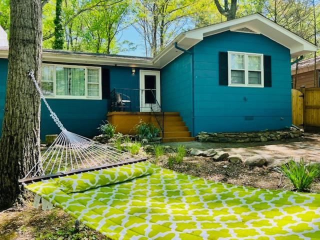a blue house with a hammock in front of it at Mountain Lake Retreat - hot tub, lake, fire pit, wineries, restaurant in Harpers Ferry