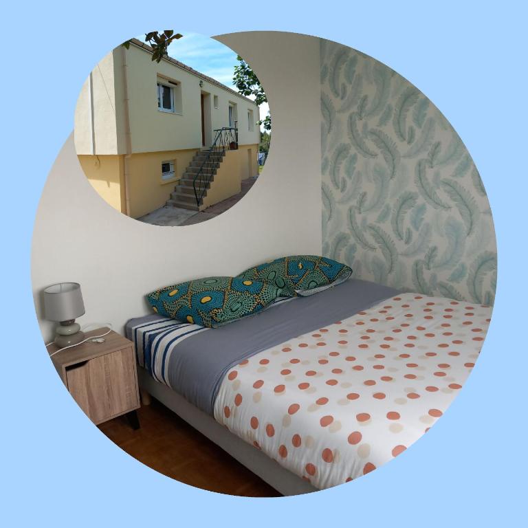 - une chambre avec un lit et un miroir rond dans l'établissement Les Cyclamens, à Cosne Cours sur Loire