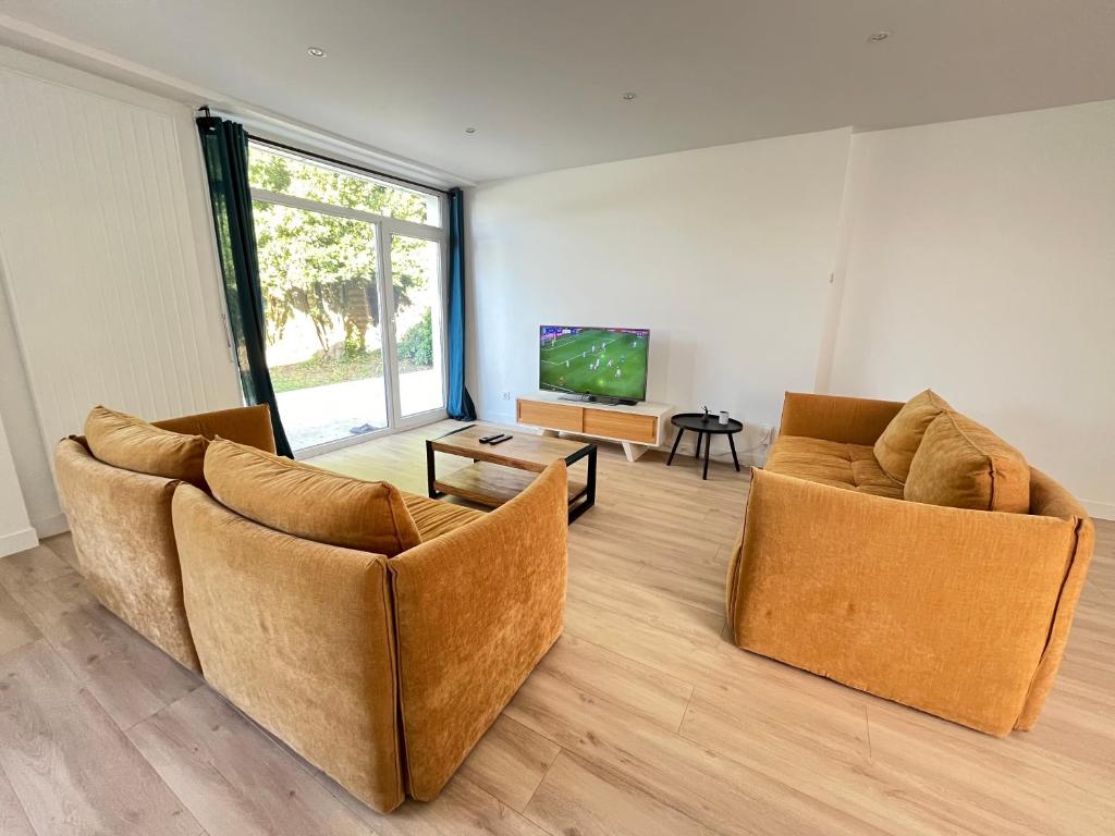 Una sala de estar con dos sillas y un televisor. en Modern House next Disneyland, en Esbly