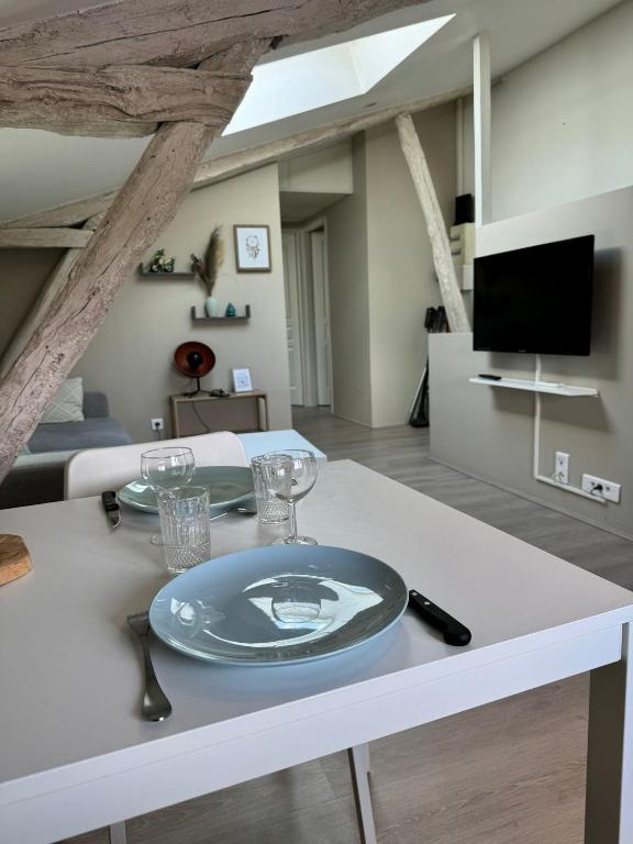 une table blanche avec une plaque au-dessus dans l'établissement Joli petit logement avec fraîcheur et confort, à Lescure-dʼAlbigeois