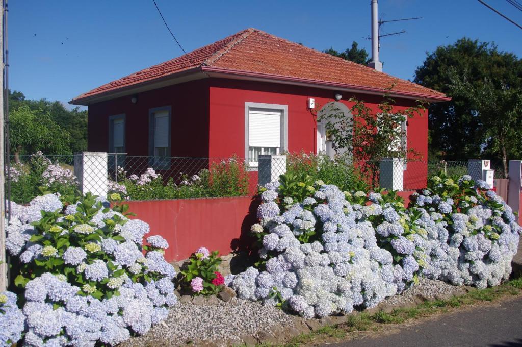ein Blumenstrauß vor einem roten Haus in der Unterkunft CAMBOTE Vivienda turìstica in Lugo
