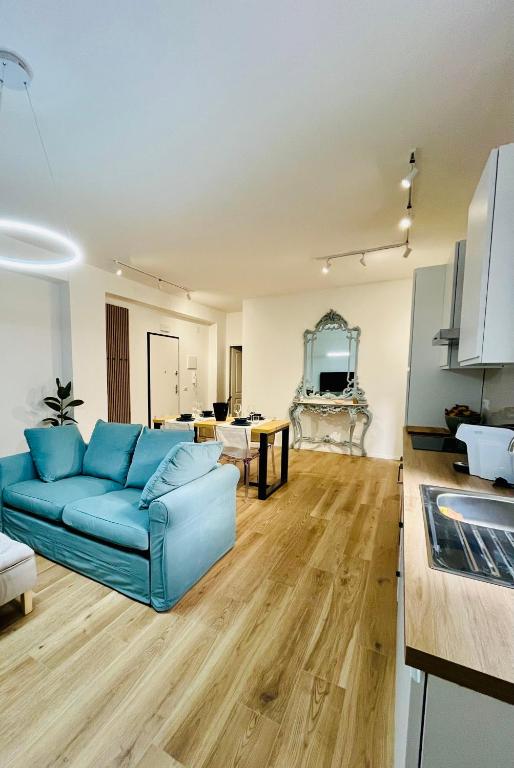 a living room with a blue couch and a kitchen at Domus Lucia in Syracuse