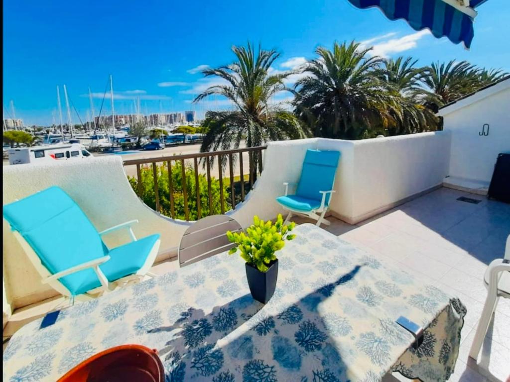 a patio with a table and chairs and a view of the ocean at LMHA25, Puerto Latino 11, Tomas Maestre Marina, La Manga in La Manga del Mar Menor