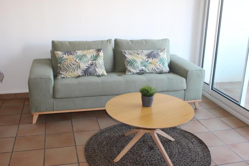 una sala de estar con un sofá y una mesa en Appartement spacieux Arcachon, en Arcachon