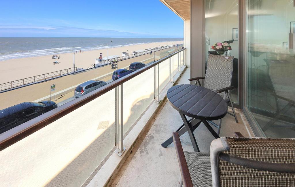 Un balcón con mesa y vista a la playa. en Residentie Vent De Sable R116, en Ostende